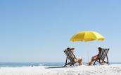 Pärchen am Strand mit gelbem Sonnenschirm