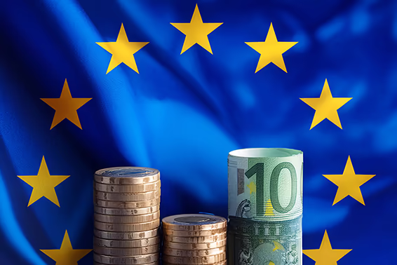 Münzen und Geldscheine vor EU-Flagge