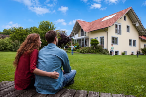 Familie im Garten vor Haus