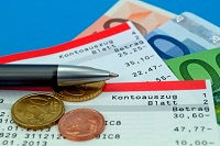 Kontoauszüge mit Bargeld und Münzen. 