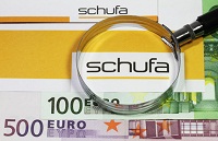 Logo der Schufa mit Lupe und Euroscheinen 