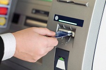 Mann hebt Geld am Automaten ab