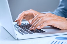 Laptoptastatur darüber tippende Hände