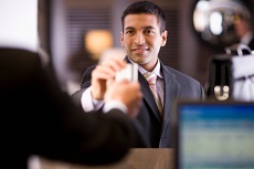 Mann reicht an der Kasse die Girocard zum Bezahlen