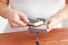 weißes Handy wird über ein Lesegerät gehalten