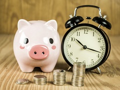 Sparschwein und Uhr nebeneinander: Bald ändert sich die gesetzliche Einlagenischerung