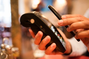 Es wird mit einem iPhone an der Kasse bezahlt