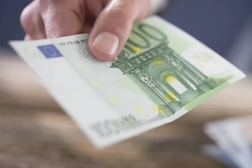 Geld abheben im Supermarkt 100 Euro Schein in der Hand