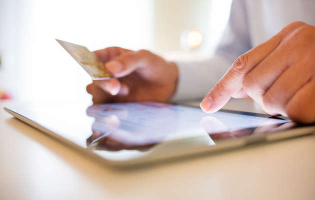 Zur Online-Zahlung per Kreditkarte wird der Verifizierungscode benötigt mann-gibt-kreditkartennummer-am-tablet-ein