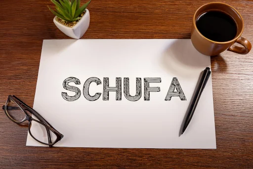 Schufa steht auf einem Dokument auf einem Schreibtisch