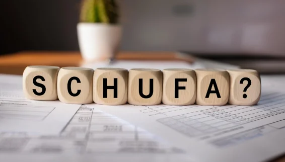 Ratgeber: Schufa-Mythen: Was beeinflusst den Score wirklich? Auf Würfeln auf einem Schreibtisch steht das Wort "Schufa?"