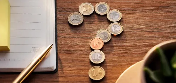 Gebühren bei der Kontokündigung Ein Fragezeichen abgebildet durch Münzen