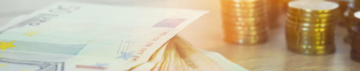 Die CHECK24 Garantie: Nirgendwo besser Bild mit Geldscheinen und Münzen von Licht angestrahlt