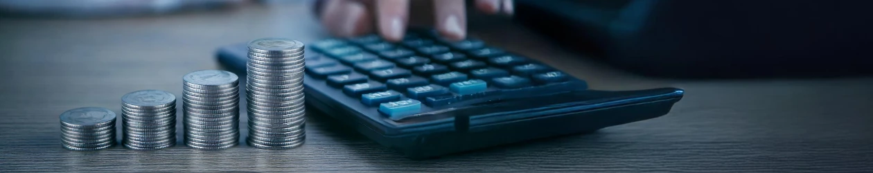 so entwickeln sich die zinsen hand am taschenrechner mit münzstapel