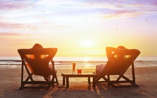 Zwei Menschen am Strand können mit Girokarte geld abheben
