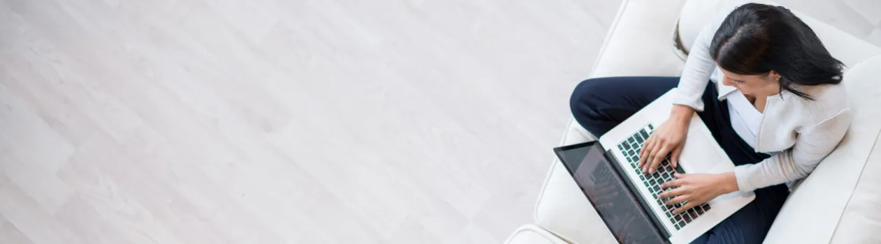 Basiskonto ermöglicht Teilnahme an Zahlungsverkehr frau-auf-sofa-mit-laptop