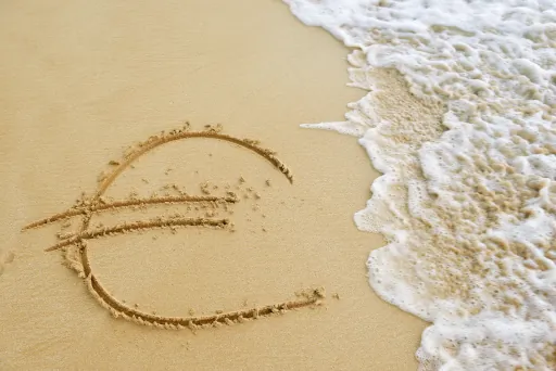 Was passiert mit meinem Kredit, wenn ich ins Ausland ziehe? symbolbild-eurozeichen-strand