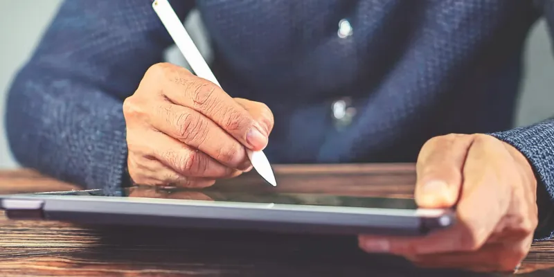 Person unterschreibt mit Stift auf Tablet