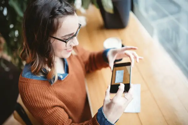 junge-frau-fotografiert-dokumente-fuer-kreditantrag