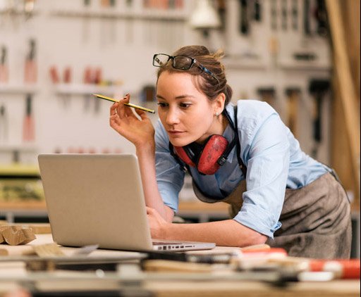 Eine Frau Steht In Einer Werkstatt Am Computer Und Sucht Einen Kredit Fur Selbststandige Eine Frau Steht In Einer Werkstatt Am Computer Und Sucht Einen Kredit Fur Selbststandige