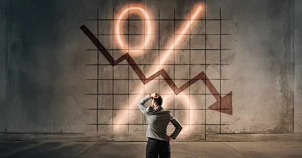 Gründe für Negativzinsen Mann vor Wand mit Graphen und Prozentzeichen