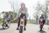 Drei Jugendliche fahren mit ihren Mopeds auf einem Feldweg.