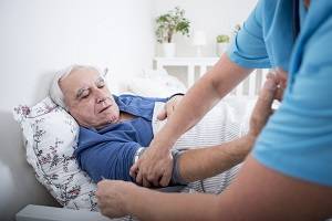 Älterer Patient im Pflegeheim kriegt den Blutdruck gemessen