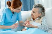 Krankenschwester gibt Seniorin Medikamente