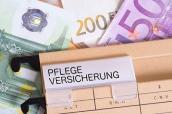 Hängeregister mit der Beschriftung "Pflegeversicherung" und Euro-Geldscheinen im Hintergrund