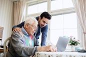 Senior mit Enkel vor Computer
