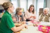 Seniorinnen mit Mädchen und Pflegerin im Pflegeheim
