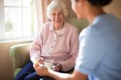 Seniorin spricht mit Krankenschwester.