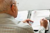 Senior unterzeichnet ein Dokument.