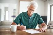 Senior unterschreibt einen Vertrag.