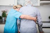 Eine Krankenschwester hilft einem Senior auf Krücken.