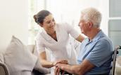 Altenpflegerin mit Senior im Rollstuhl