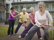 Trainerin mit Gruppe von Senioren bei Gymnastik-Kurs
