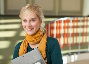 Studentin steht im Treppenhaus