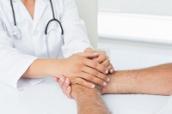 Ärztin hält Hand eines Patienten