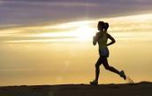 Joggerin bei Sonnenuntergang am Strand