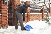 Mann beim Schneeschippen