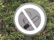 Schild "Rauchverbot" auf Rasen.