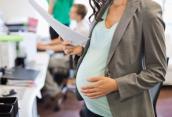 Schwangerschaftsbauch Nahaufnahme und Papiere in Hand