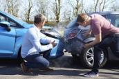 Nach einem Auffahrunfall begutachten die beiden Autofahrer den Schaden.