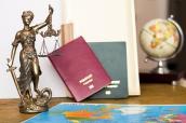 Justitia neben Landkarte und Reisepässen