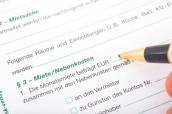 Auf einem Mietvertrag wird die Miete eingetragen