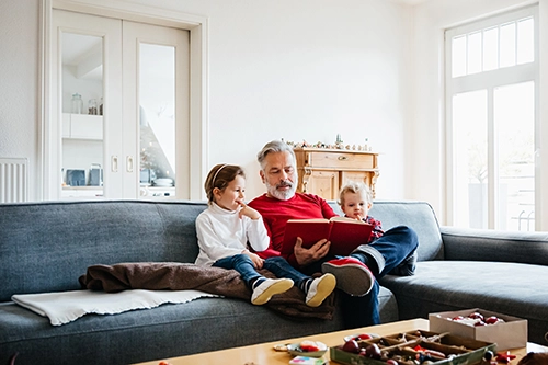 Gesetzliche Rentenversicherung: Großvater mit Enkelkindern auf dem Sofa