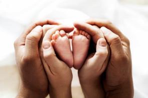 Hände von Vater, Mutter und Baby