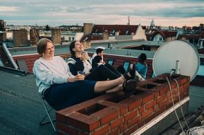Junge Menschen sitzen auf einem Dach in Berlin.