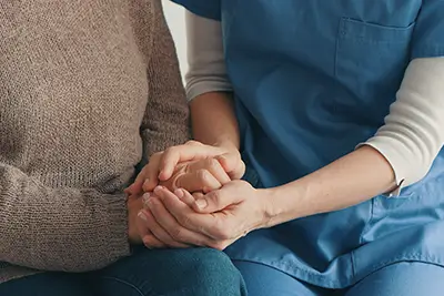 Eine Pflegerin tröstet eine Angehörige im Todesfall